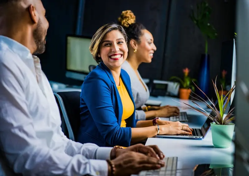 Optimizing business processes through teamwork and efficiency. Three diverse professionals collaborating at a table, streamlining business processes and workflow efficiency.