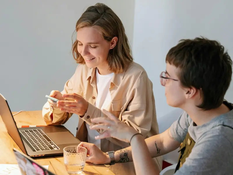 Two young professionals brainstorming ideas, representing innovative solutions and streamlined technology systems.